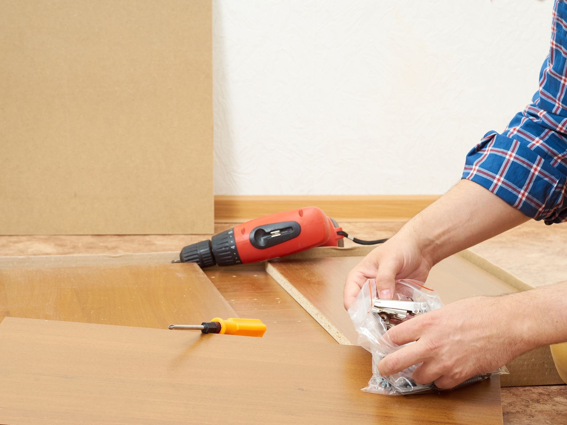 Man in shirt assemble furniture. Domestic work. Craftsman. Carpenter.   Man in shirt assemble furniture. Domestic work. Craftsman. Carpenter.